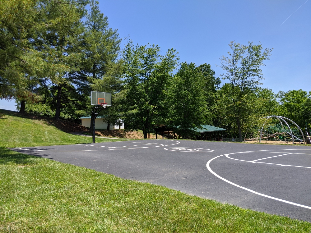 The outdoor basketball court at Mid County Park is next to the playground, picnic shelters, and restroom.